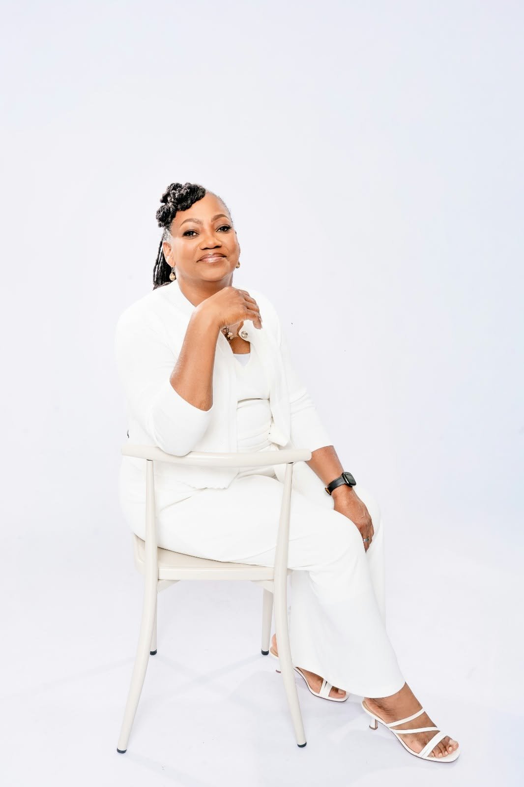 A woman in white sitting comfortably on a chair.